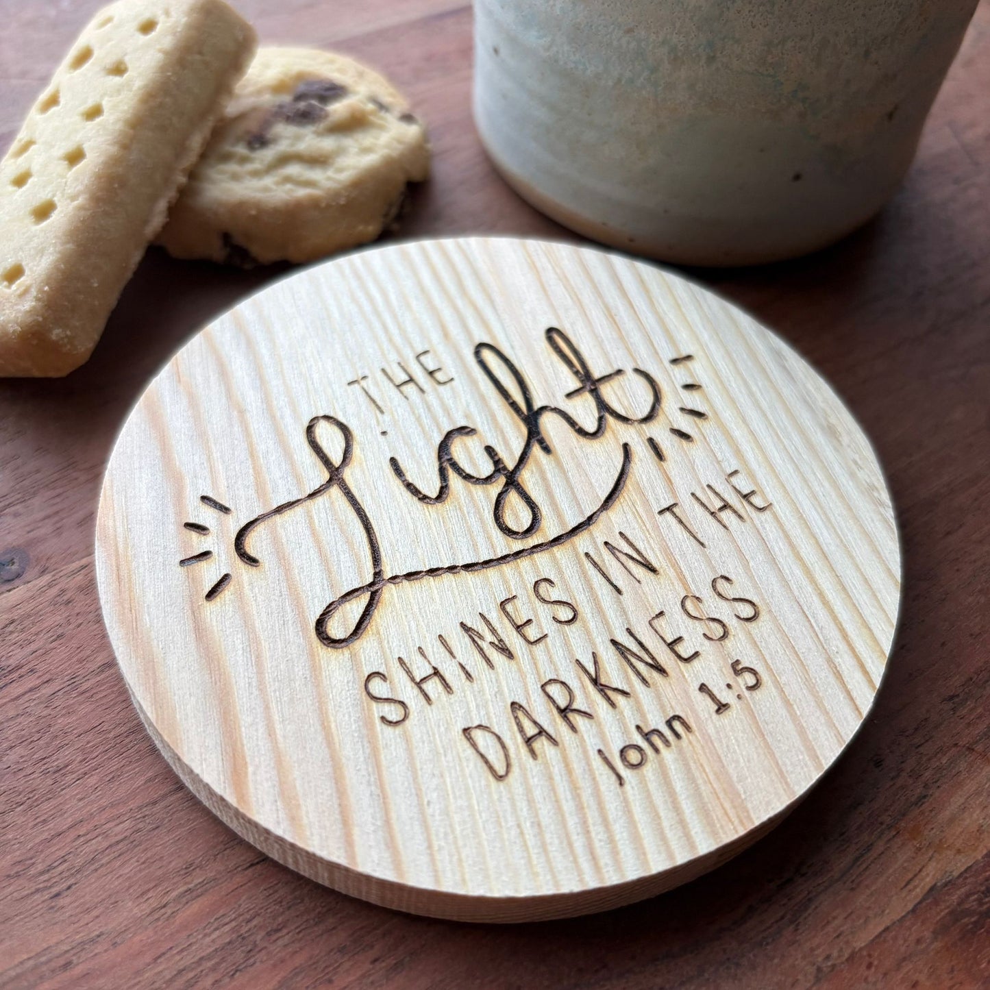‘The light shines in the darkness' wooden coaster